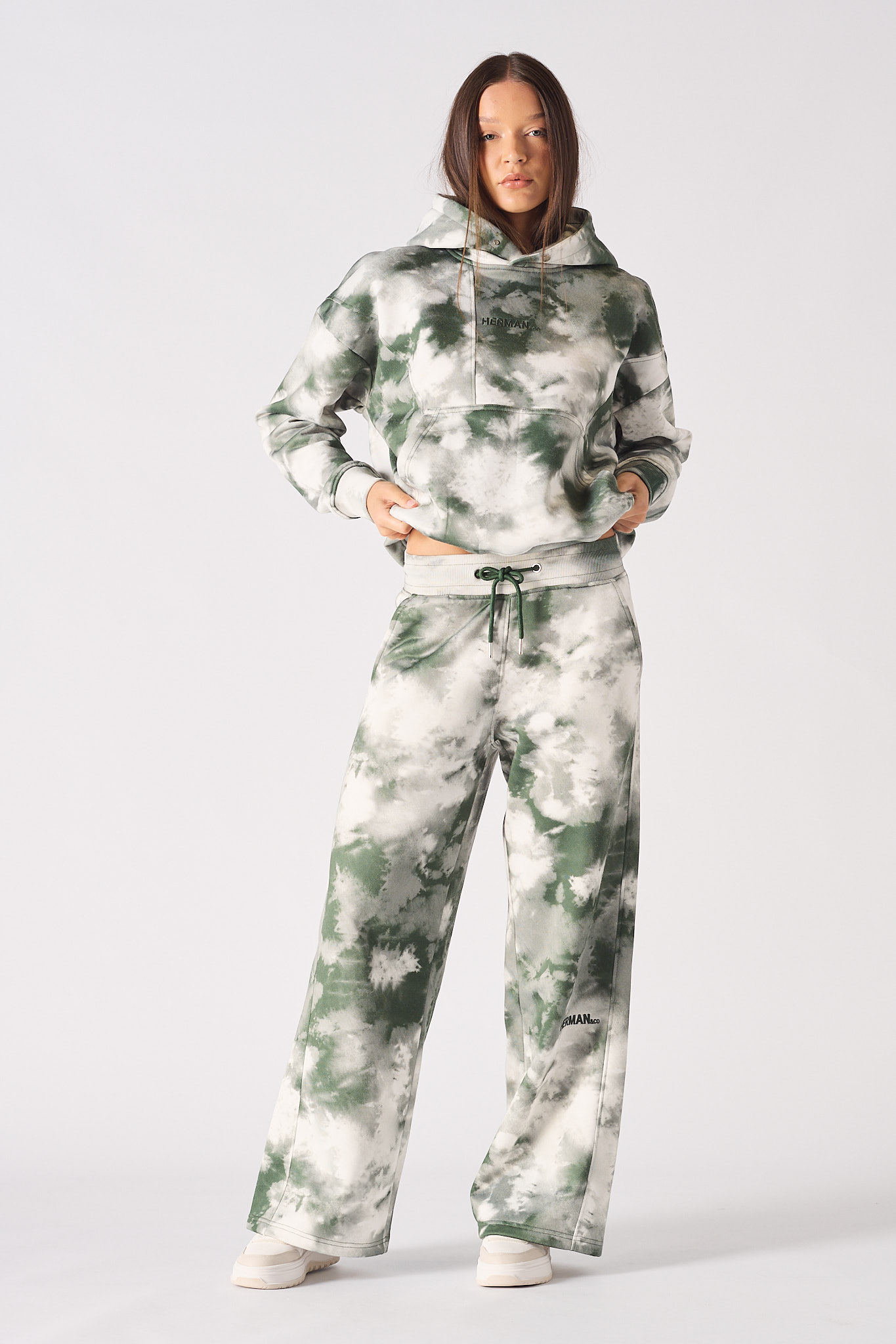 A model styled in the women's green tie-dye joggers and cropped hoodie.
