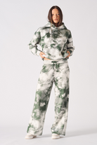A model styled in the women's green tie-dye joggers and cropped hoodie.