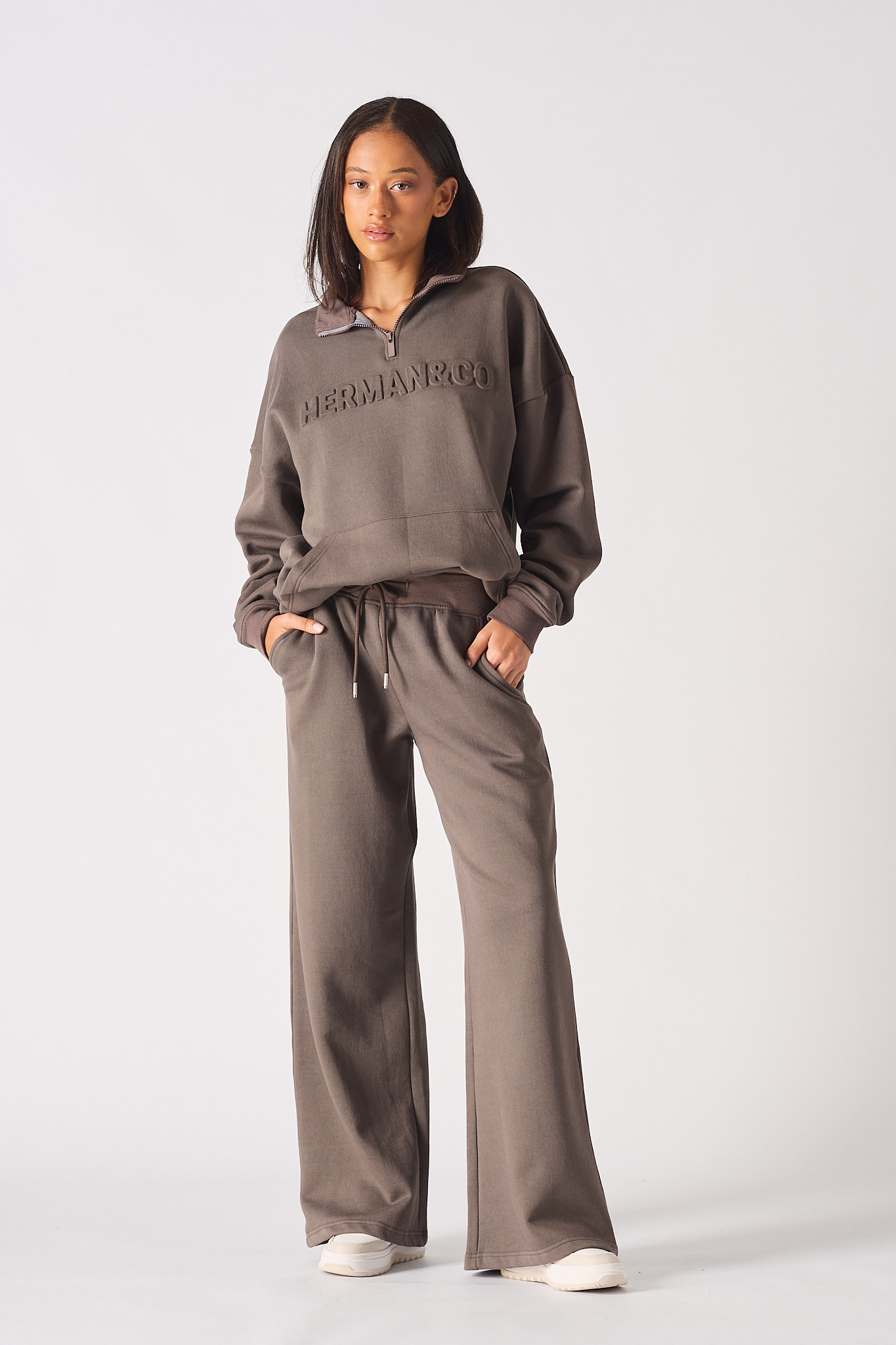 A model showing how to style the women's baggy joggers in brown.