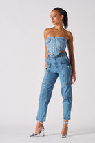 A model styled in the women's blue cargo jeans with a matching denim corset top.
