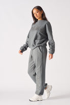 A model styled in the women's grey cuffed joggers with a matching sweatshirt.