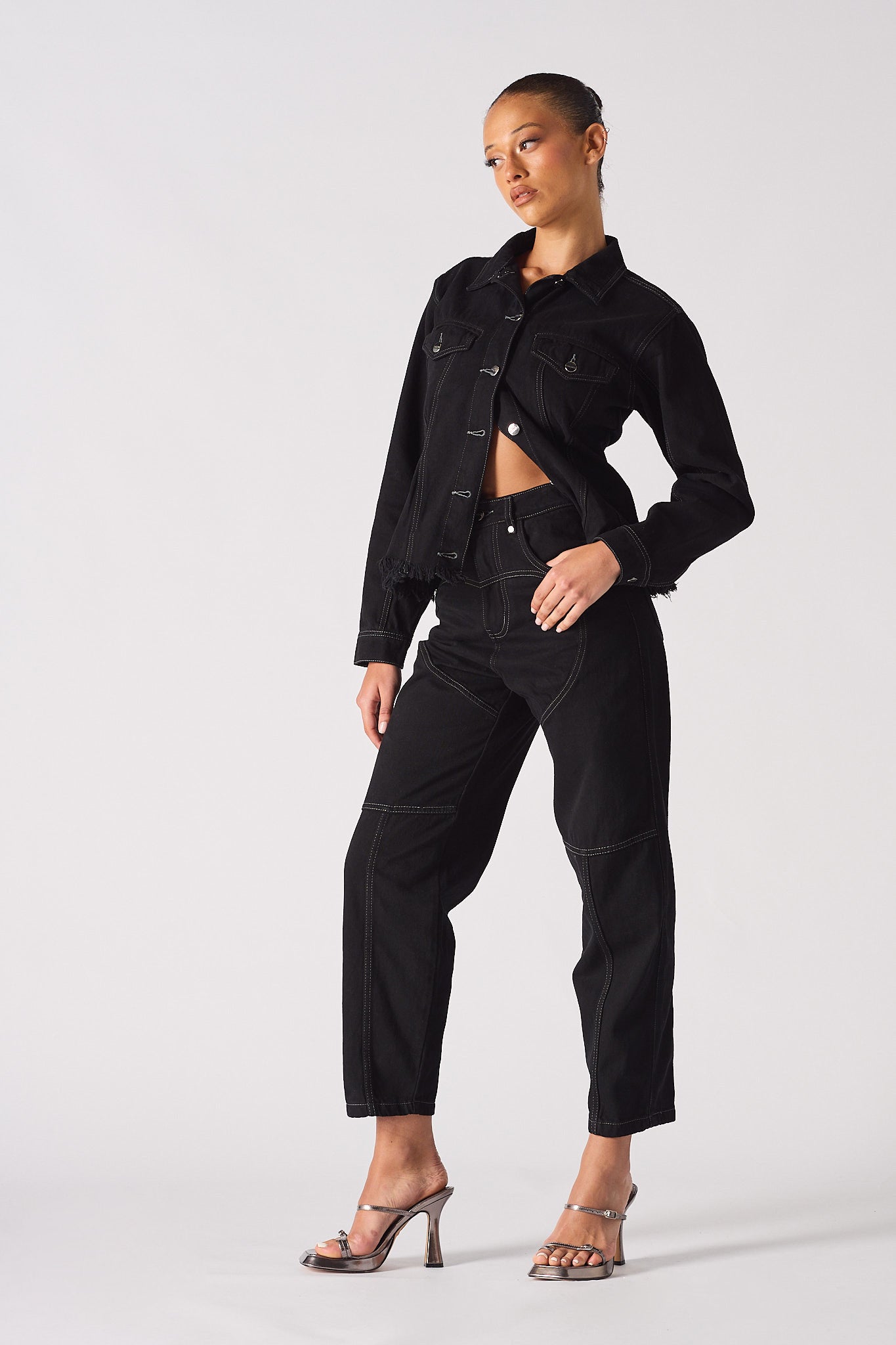 Angled side view of the tapered denim waist jacket.