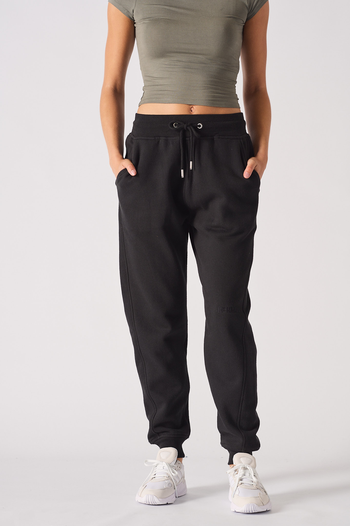 A model with hands in pockets wearing the tapered women's joggers in black