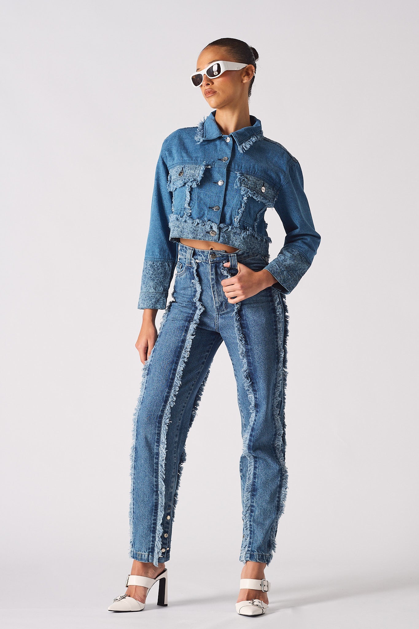 A model wearing the two-tone distressed denim crop jacket with matching jeans.