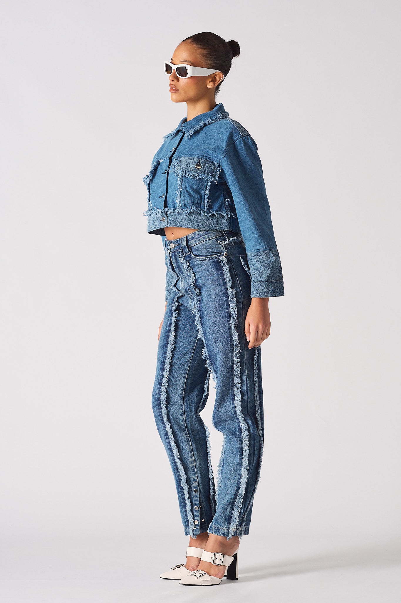 Side profile of a model in the two-toned denim jacket and jeans set.
