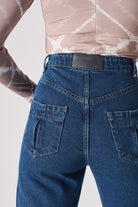 Close-up of the back pocket and logo patch on the whisker jeans for women.