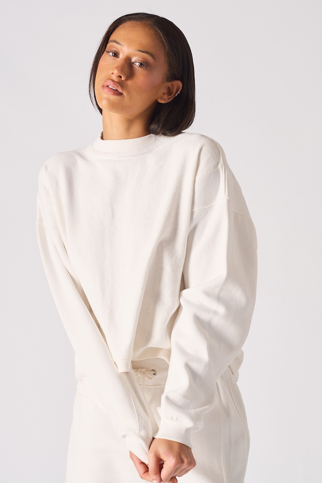 Detailed view of the ribbed sleeve cuff on the white crew neck jumper womens
