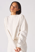 Detailed view of the ribbed sleeve cuff on the white crew neck jumper womens