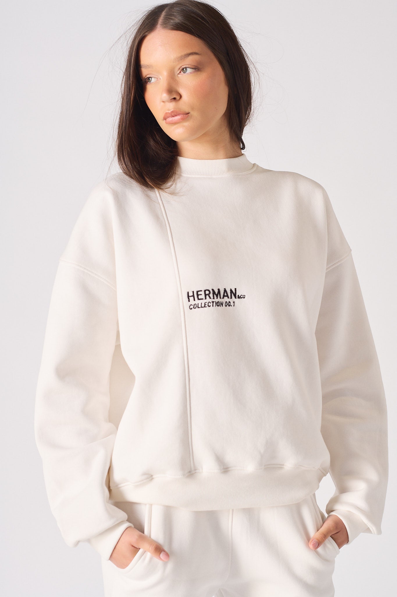 Model standing in limited edition white crewneck sweatshirt women's casual look