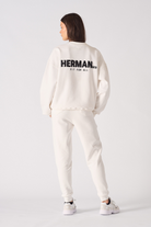 Rear view showing the large black logo print on the back of the white sweatshirt