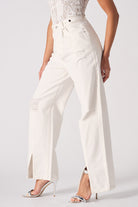 Side view of the women's white distressed wide-leg jeans with a side split hem.