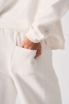 Detailed view of the side pocket on the white wide-leg joggers for women.
