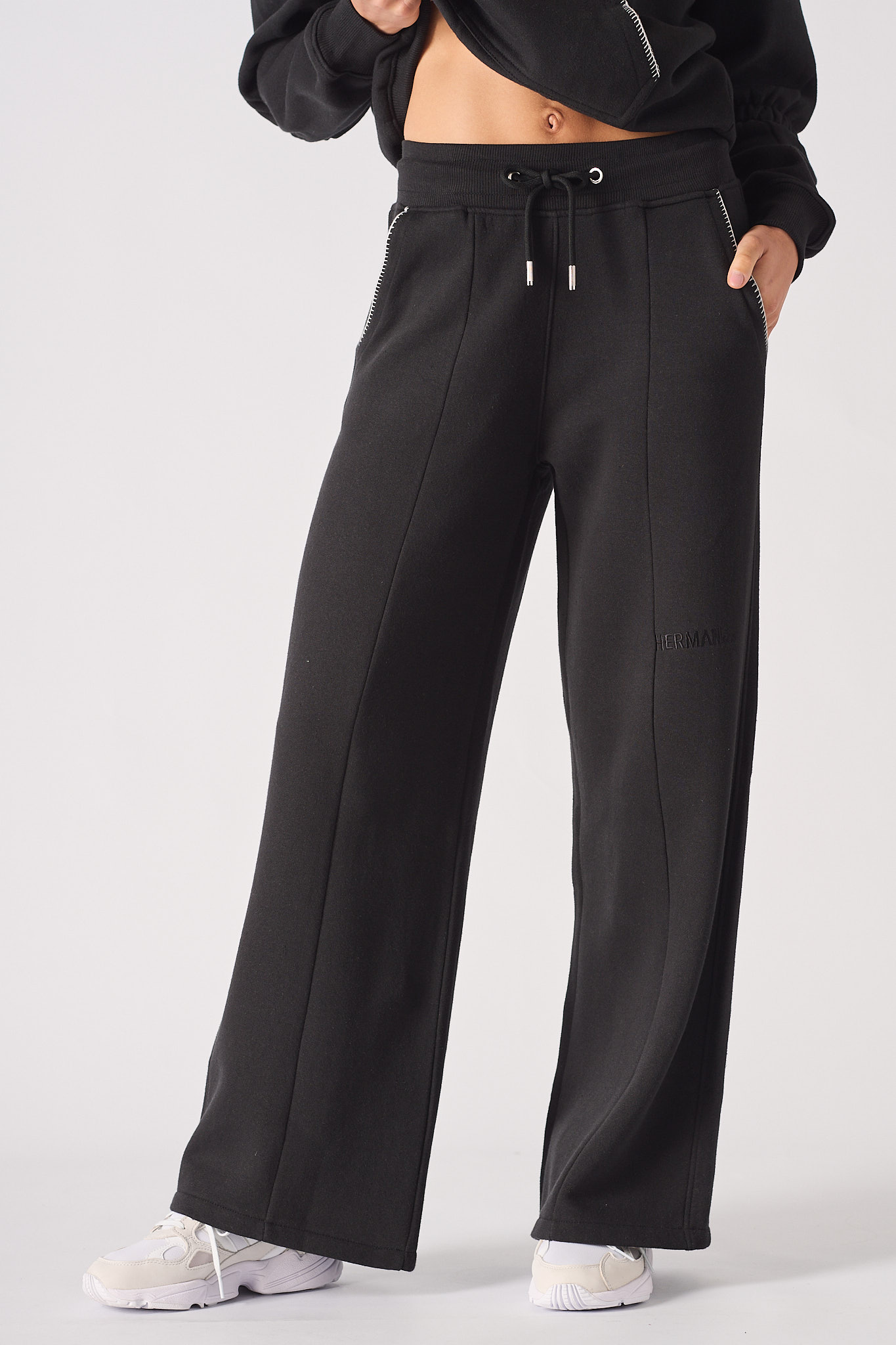 Front view of wide leg joggers in black showing the relaxed fit and contrast stitch