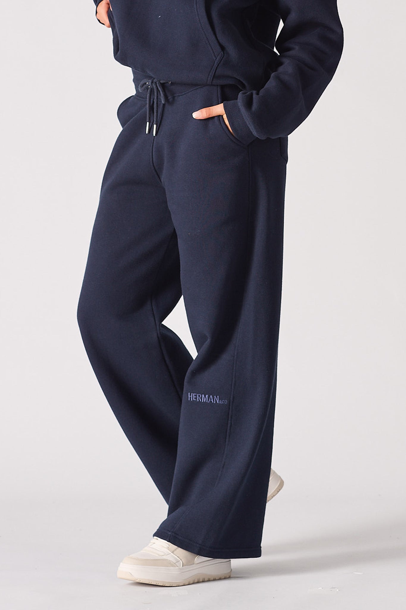 Angled side view of the wide-leg navy joggers for women showing the logo.