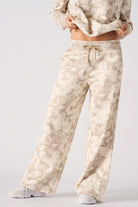 Side profile view showing the loose fit of women's beige tie dye joggers