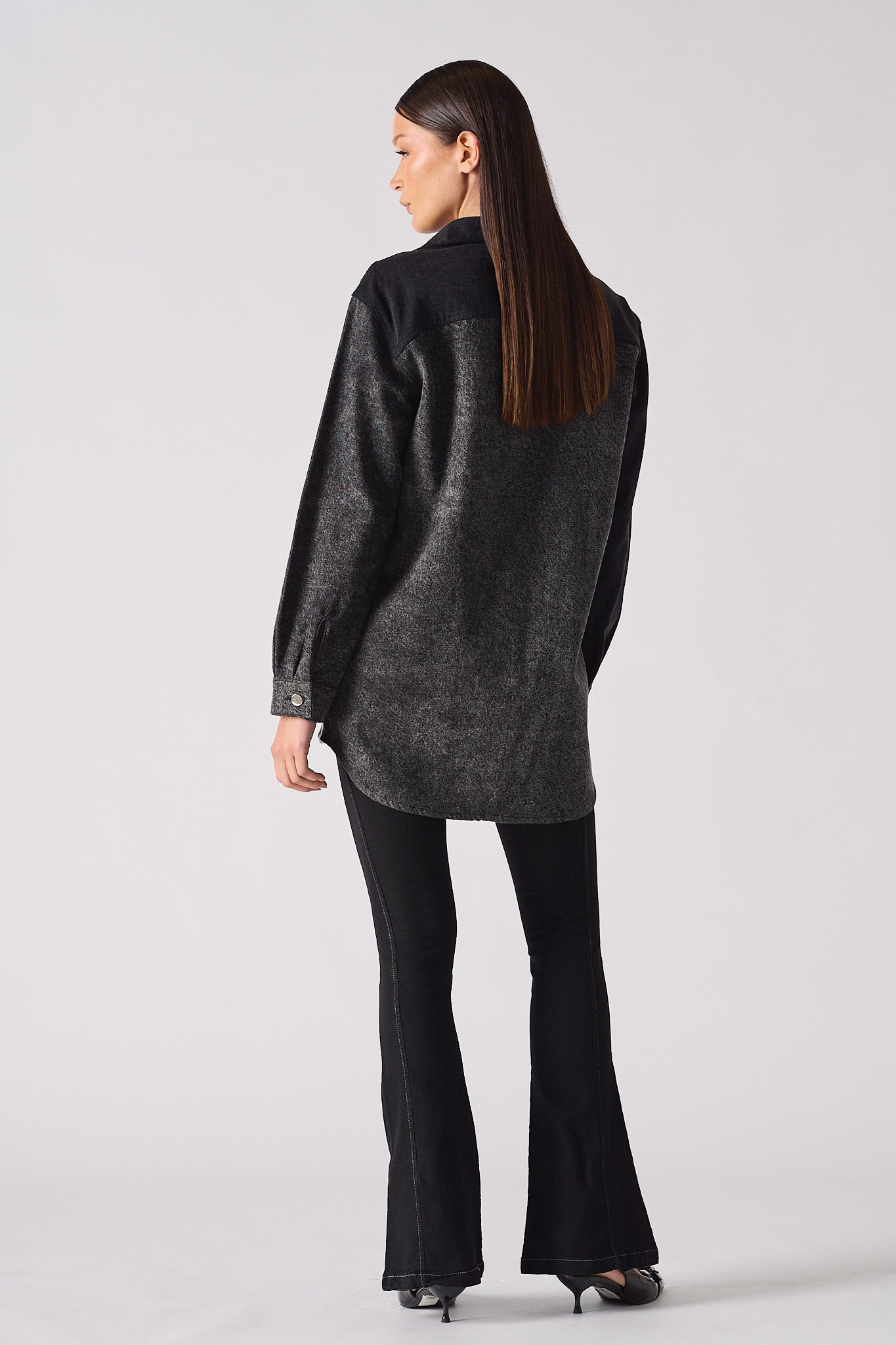 Back view of a model wearing the women's acid washed denim shirt.