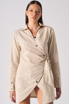 Close-up of the women's beige asymmetric shirt dress, showing the collar and buttons.