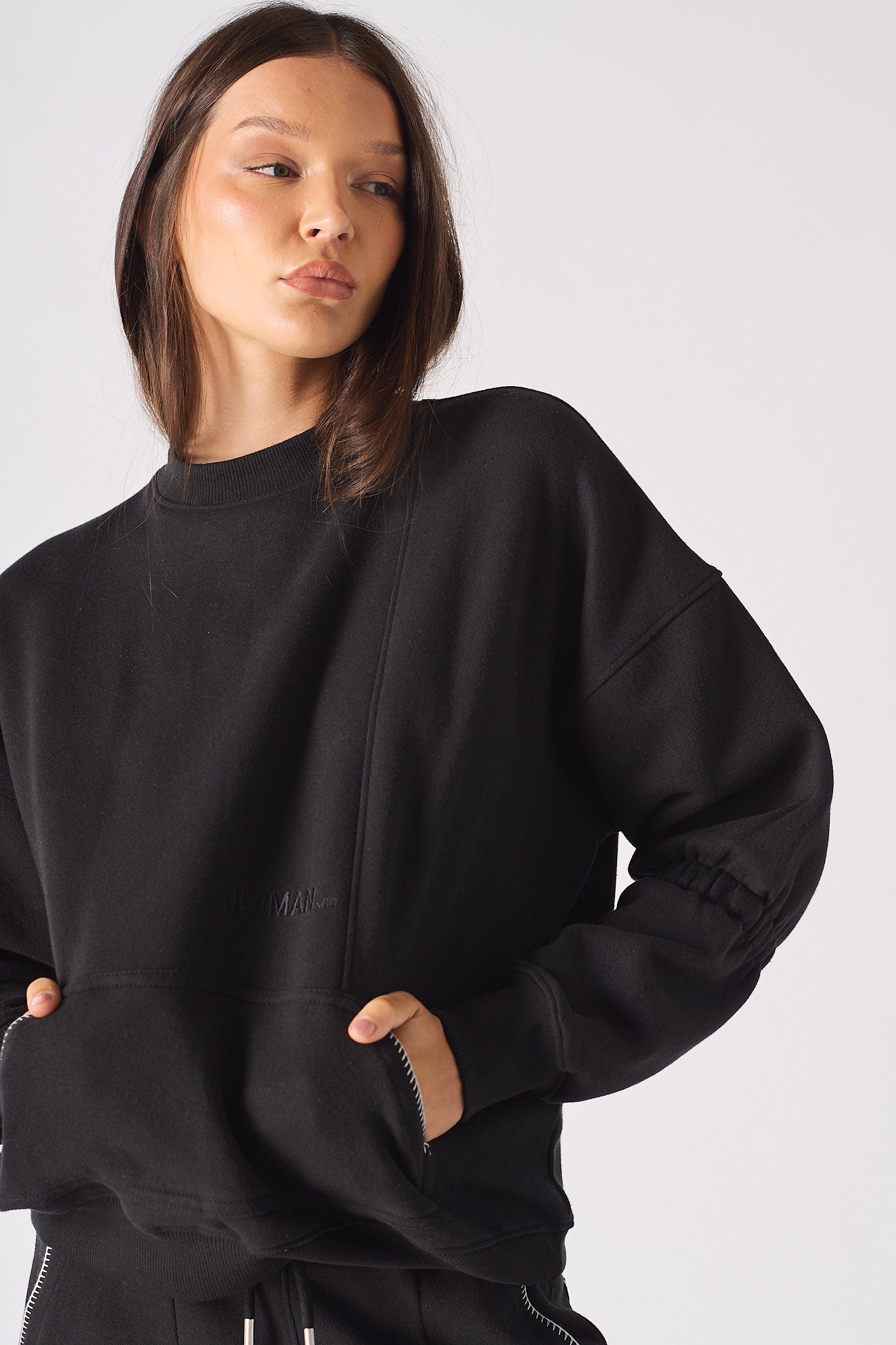 Close-up of the women's black jumper with blanket stitch pockets.