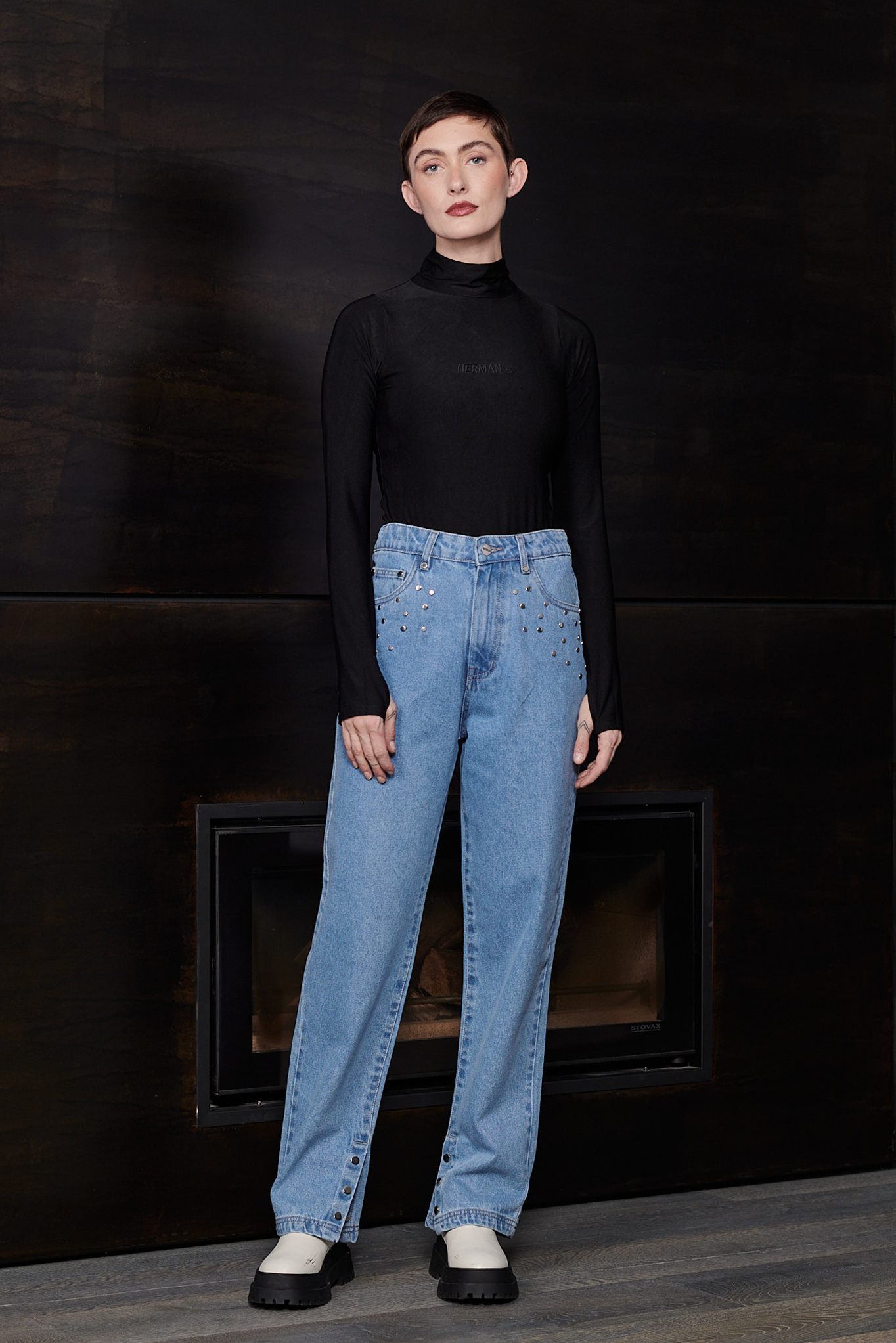 Full view of a model styled in the women's black spandex bodysuit and jeans.