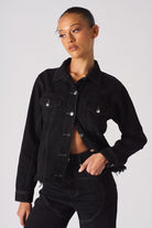 A model wearing the women's black tapered waist denim jacket.