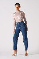 A model styled in the women's dark wash whisker jeans.