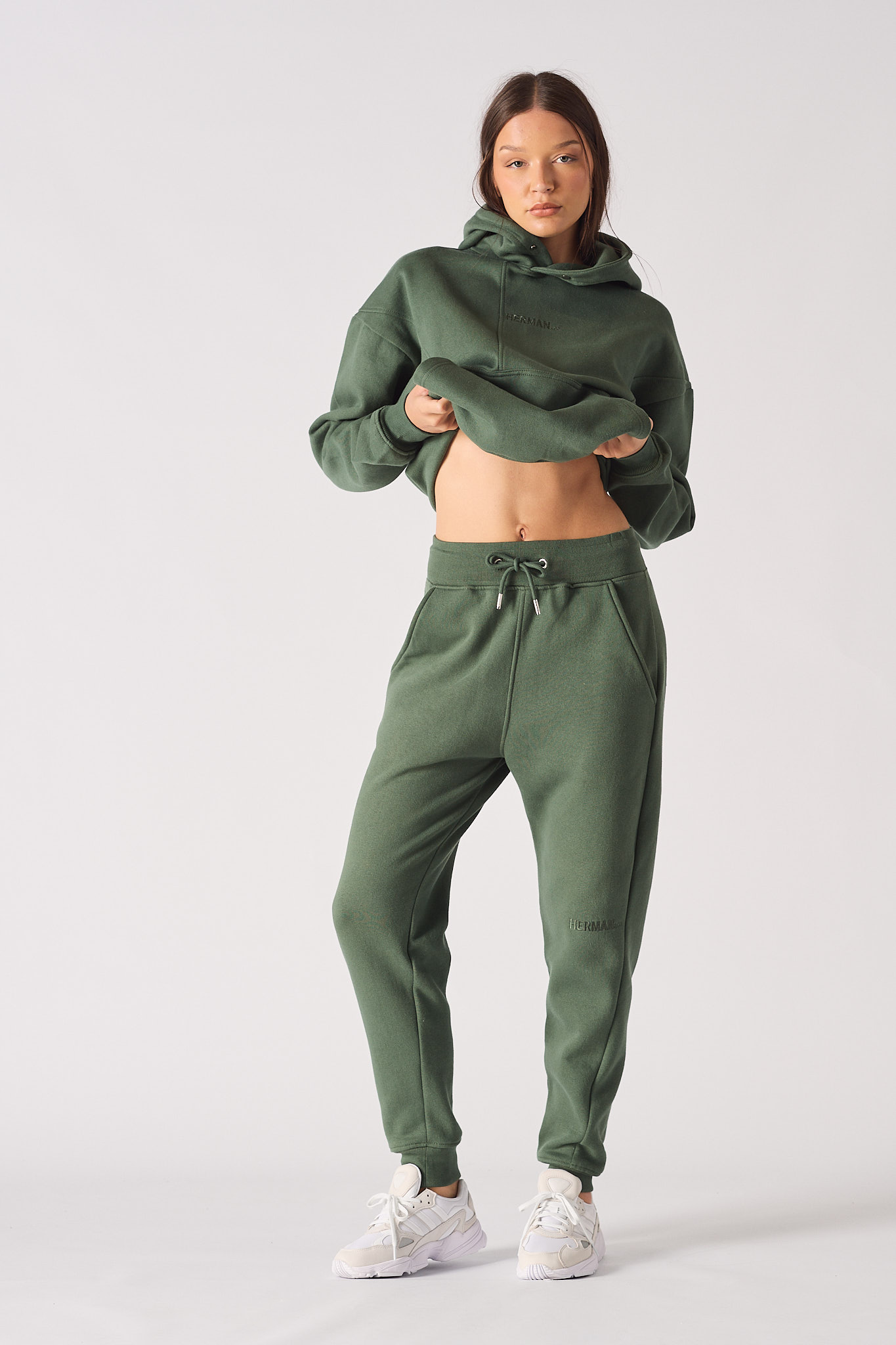 A model wearing the women's green tapered joggers and a matching cropped hoodie.
