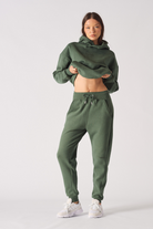 A model wearing the women's green tapered joggers and a matching cropped hoodie.