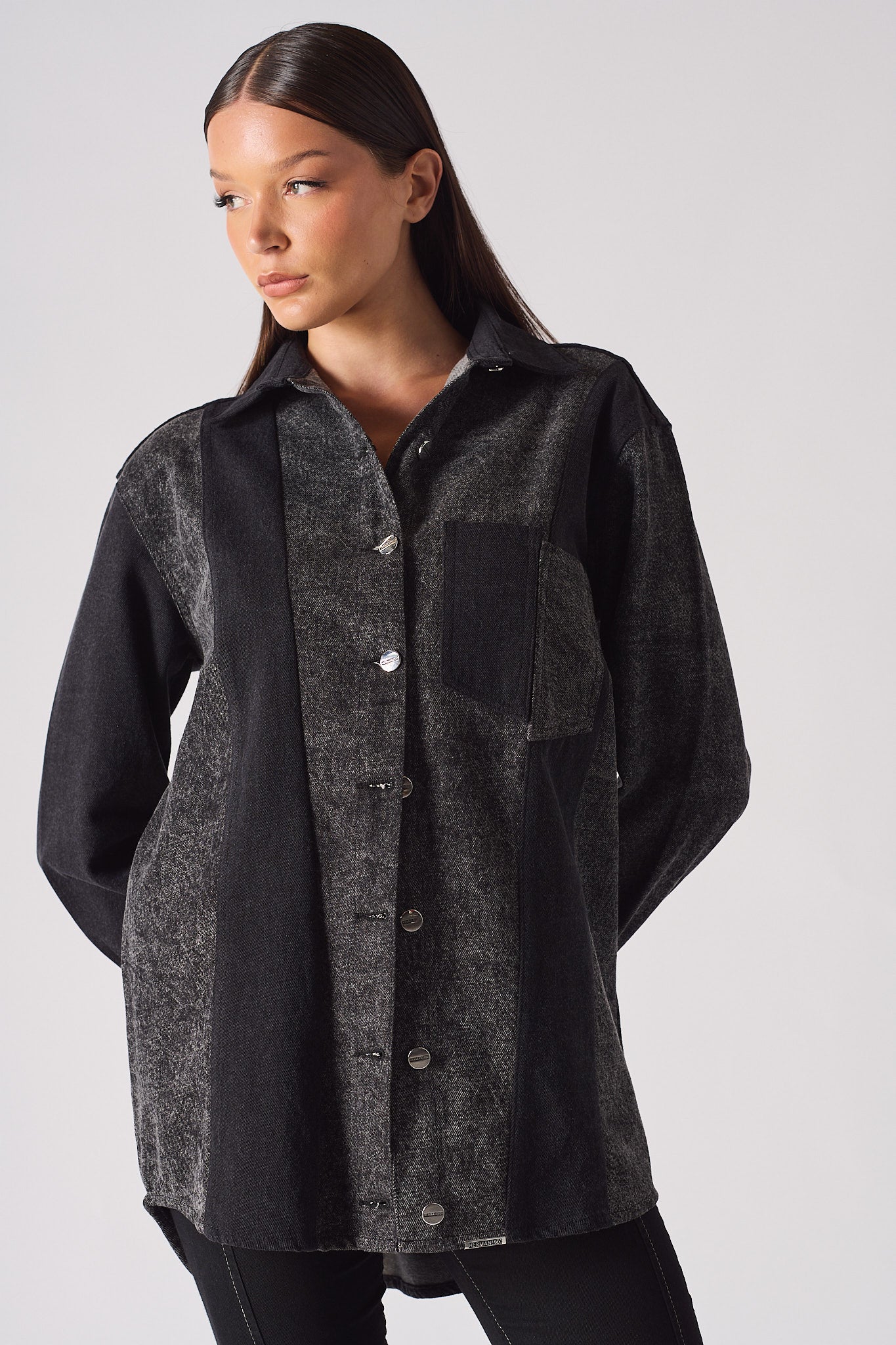 A model showing the fit of the women's longline acid wash denim shirt.