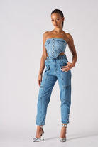 Full front view of a model wearing the women's mid-wash cargo jeans.