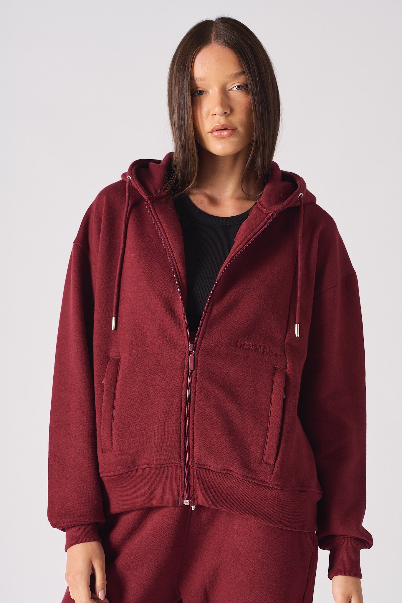A model in the women's oversized red zip-up hoodie.