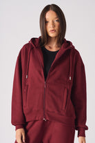 A model in the women's oversized red zip-up hoodie.