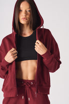 Close-up of the zip and hood on the women's red zip-up hoodie.