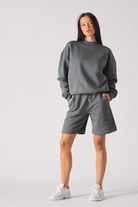 Front pose of model with hands in pockets of cool grey fleece shorts