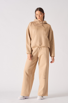 Front view of model wearing womens beige hoodie with matching wide leg joggers