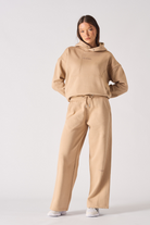 A model wearing the women's beige joggers with a matching hoodie.