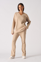 Close up view of the ribbed v neckline on womens beige jumper