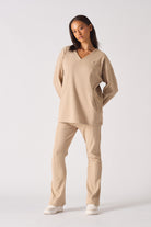Front view of model wearing womens beige v neck jumper with matching trousers