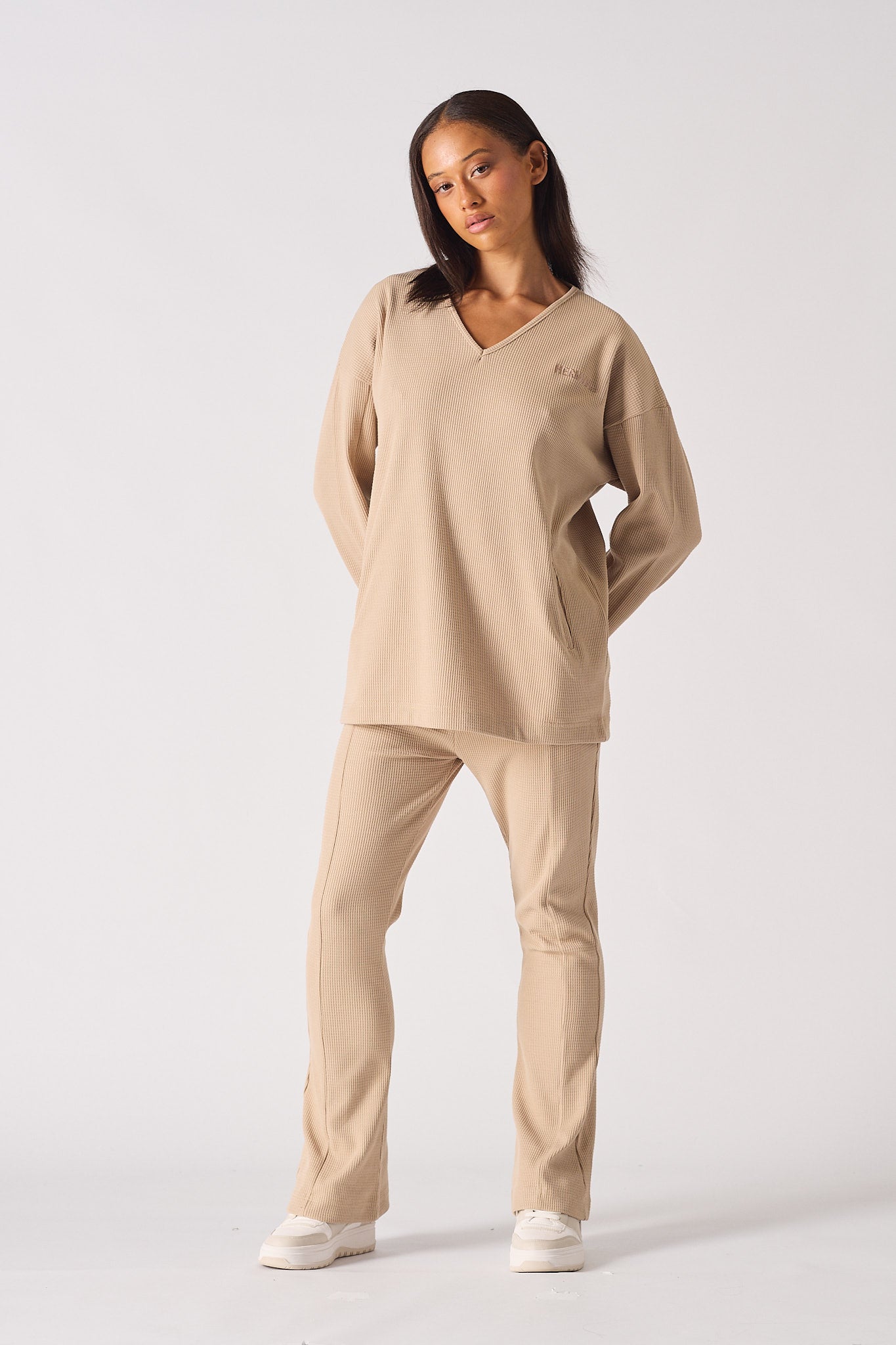 Model wearing the complete beige waffle co-ord set with flare joggers and v-neck top