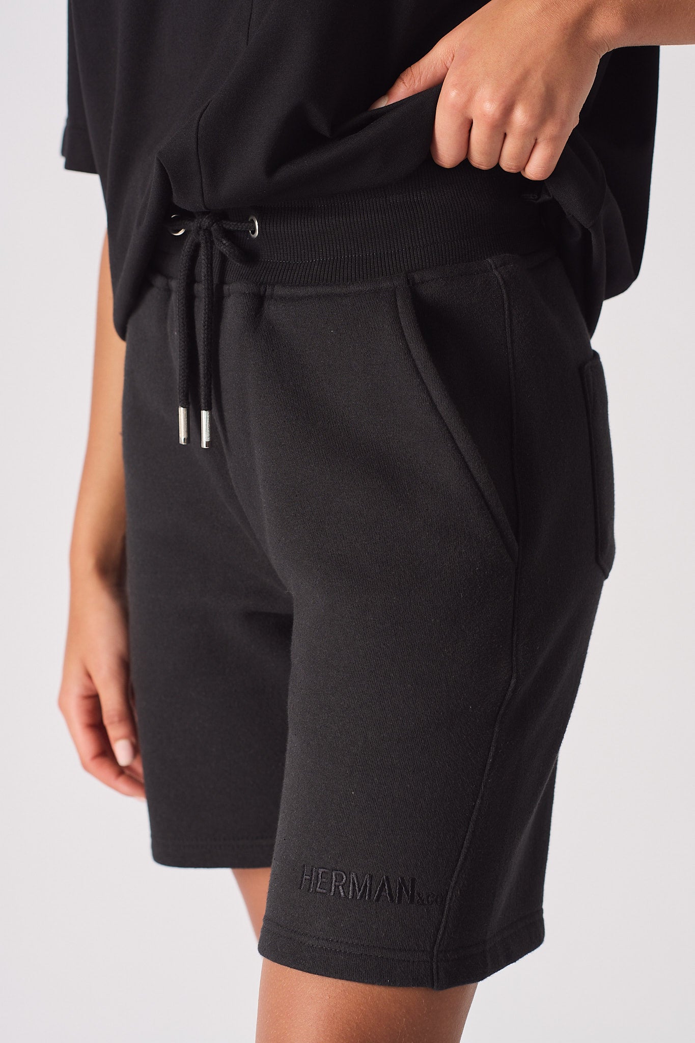 Flat lay front view of essential womens black fleece shorts