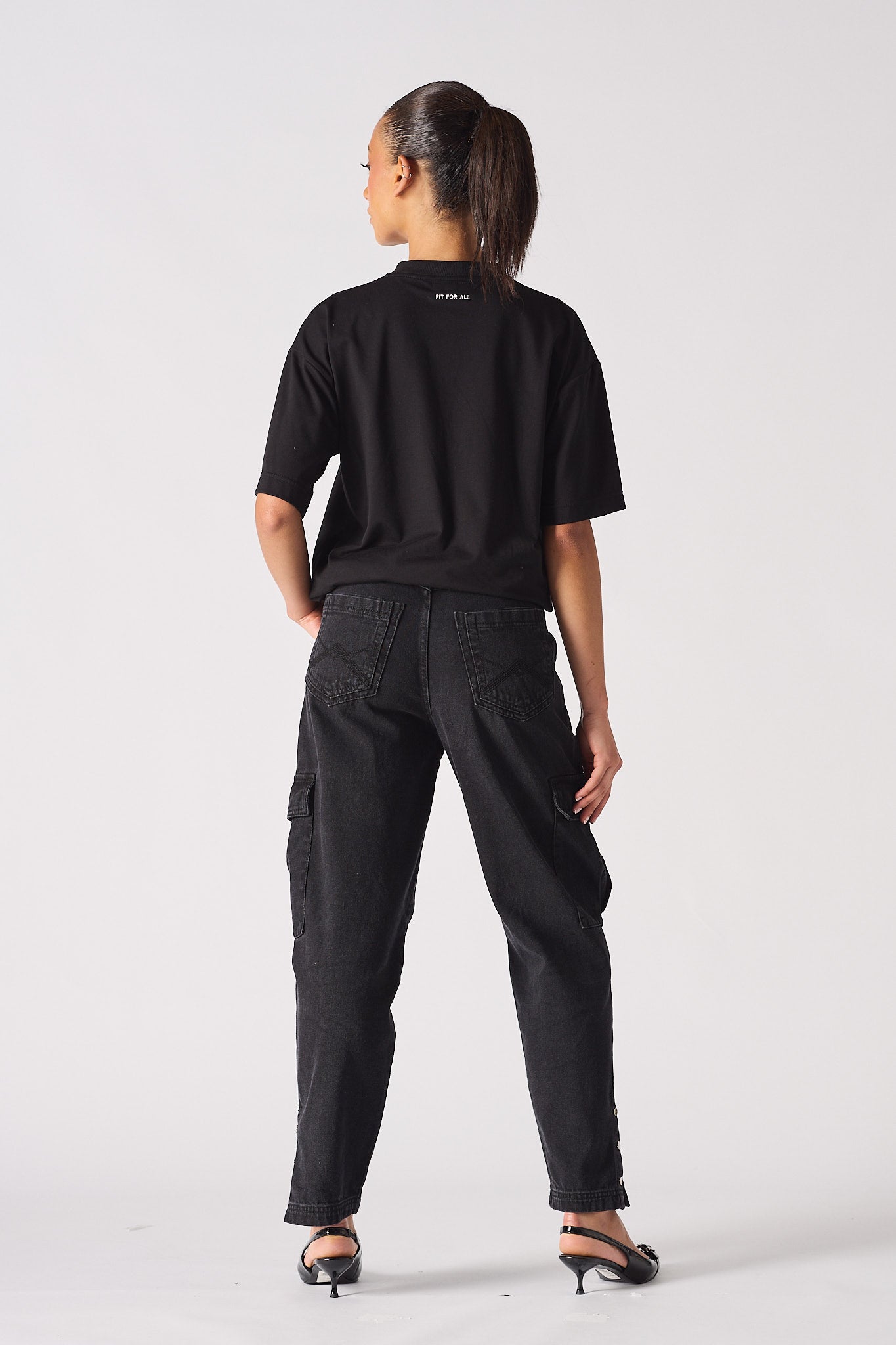 Back view of a model wearing the women's black cargo jeans.