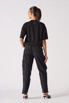 Back view of a model wearing the women's black cargo jeans.