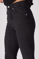 Side close-up of the ribbed biker detail on the knee of the women's black jeans.