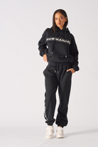 Back view of model standing in black oversized joggers showing loose fit