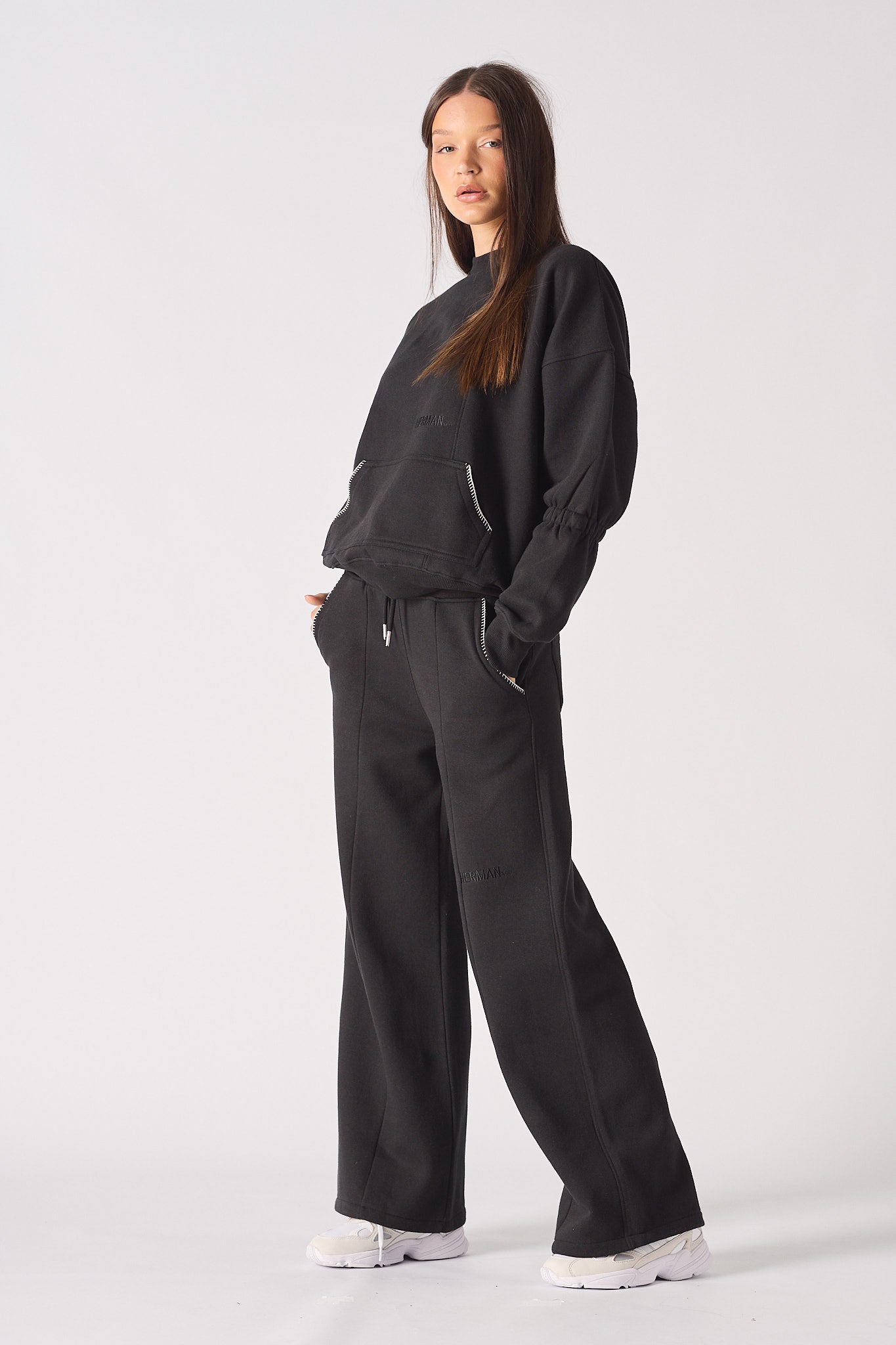 Model walking in black wide leg joggers showcasing the casual streetwear drape
