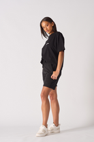 Side profile view showing the length and fit of womens black shorts