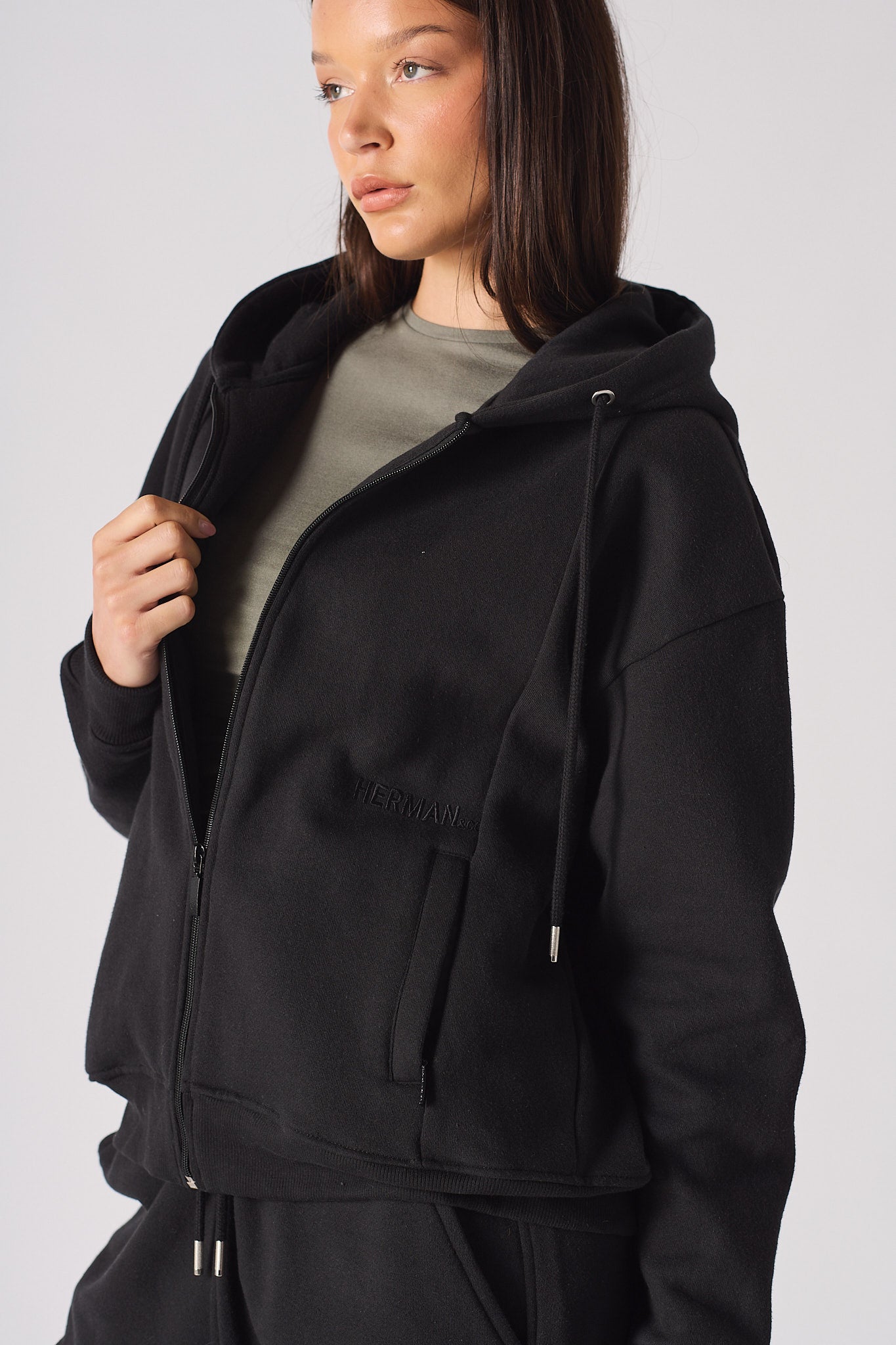 Close up view of the hood and zipper detail on black womens hoodie