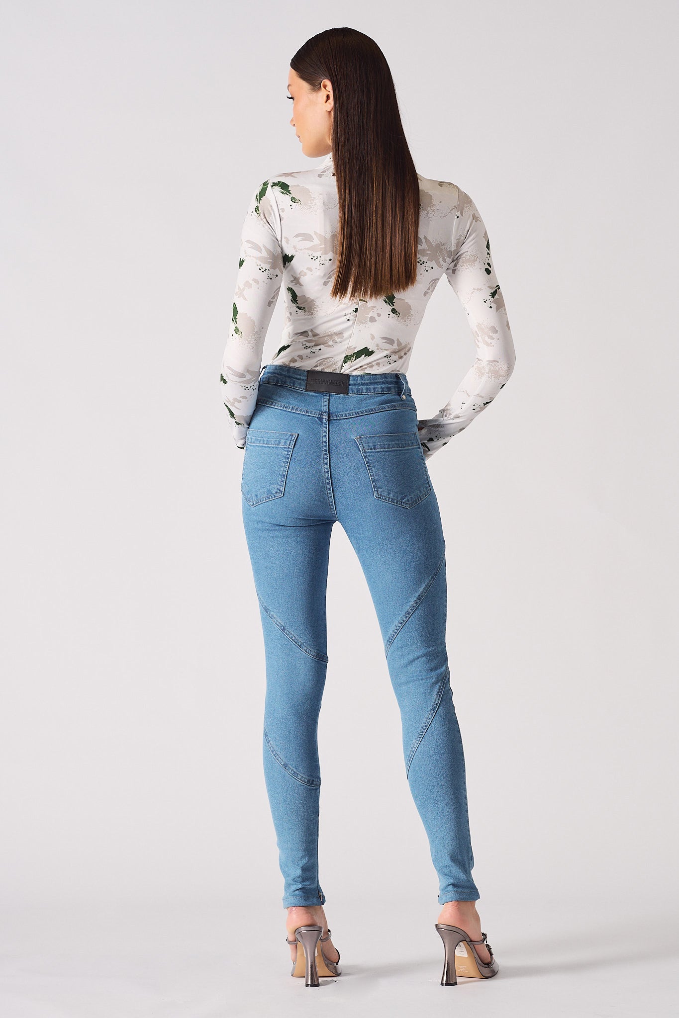 Back view of a model in the women's blue high-waisted skinny jeans.