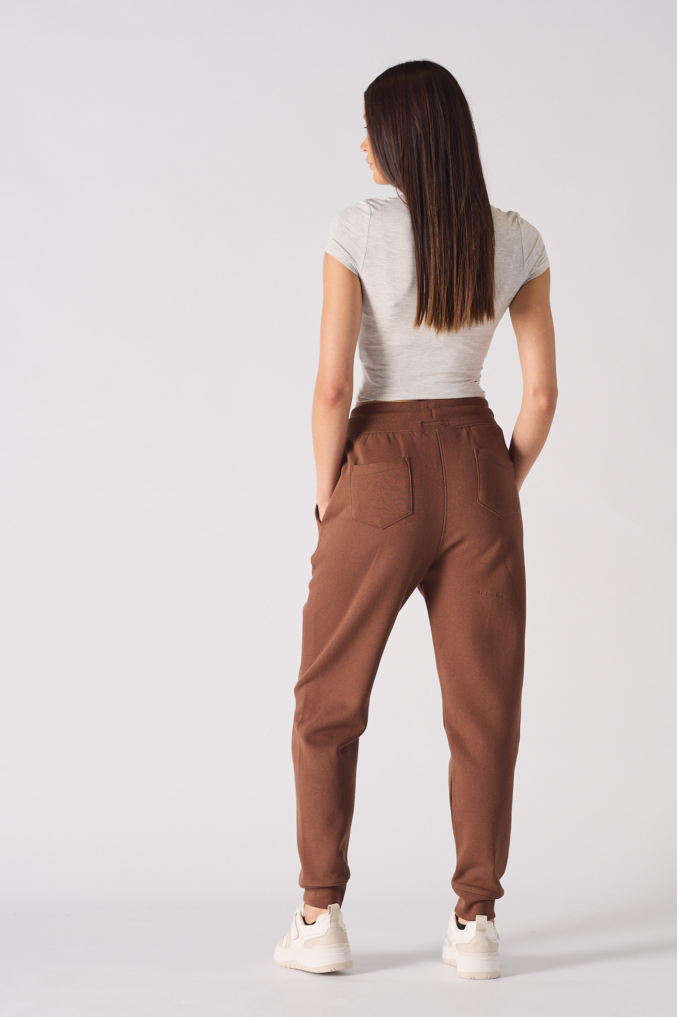 Back view of a model wearing the women's brown tapered joggers.