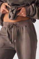 Close-up of the drawstring waist on the women's brown baggy joggers.