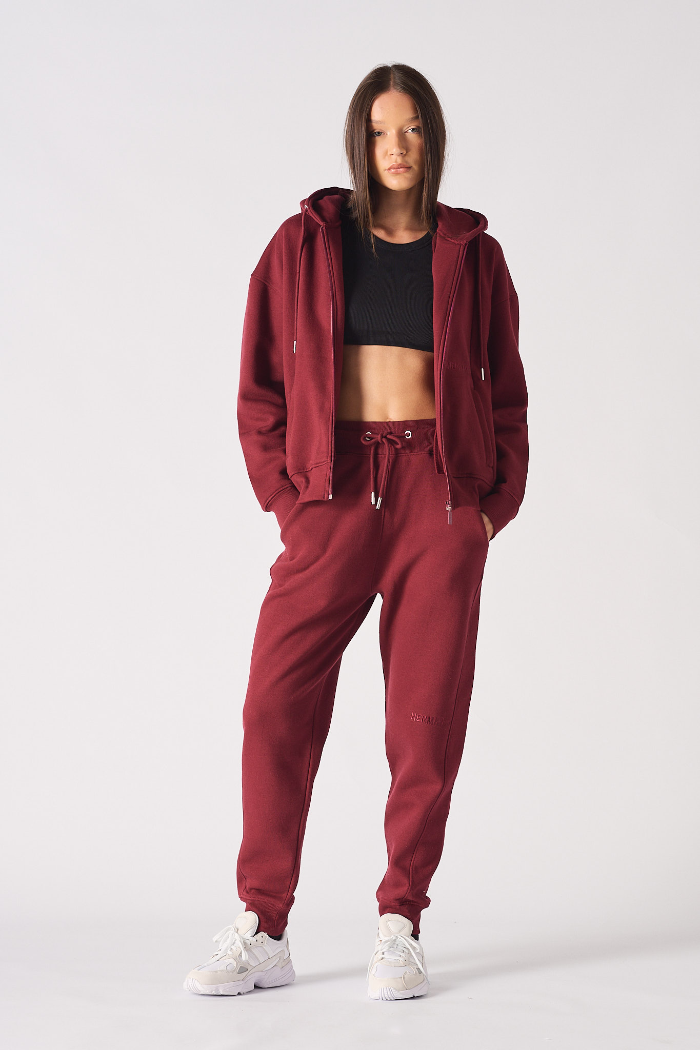 Model posing in burgundy tapered joggers for a casual streetwear look